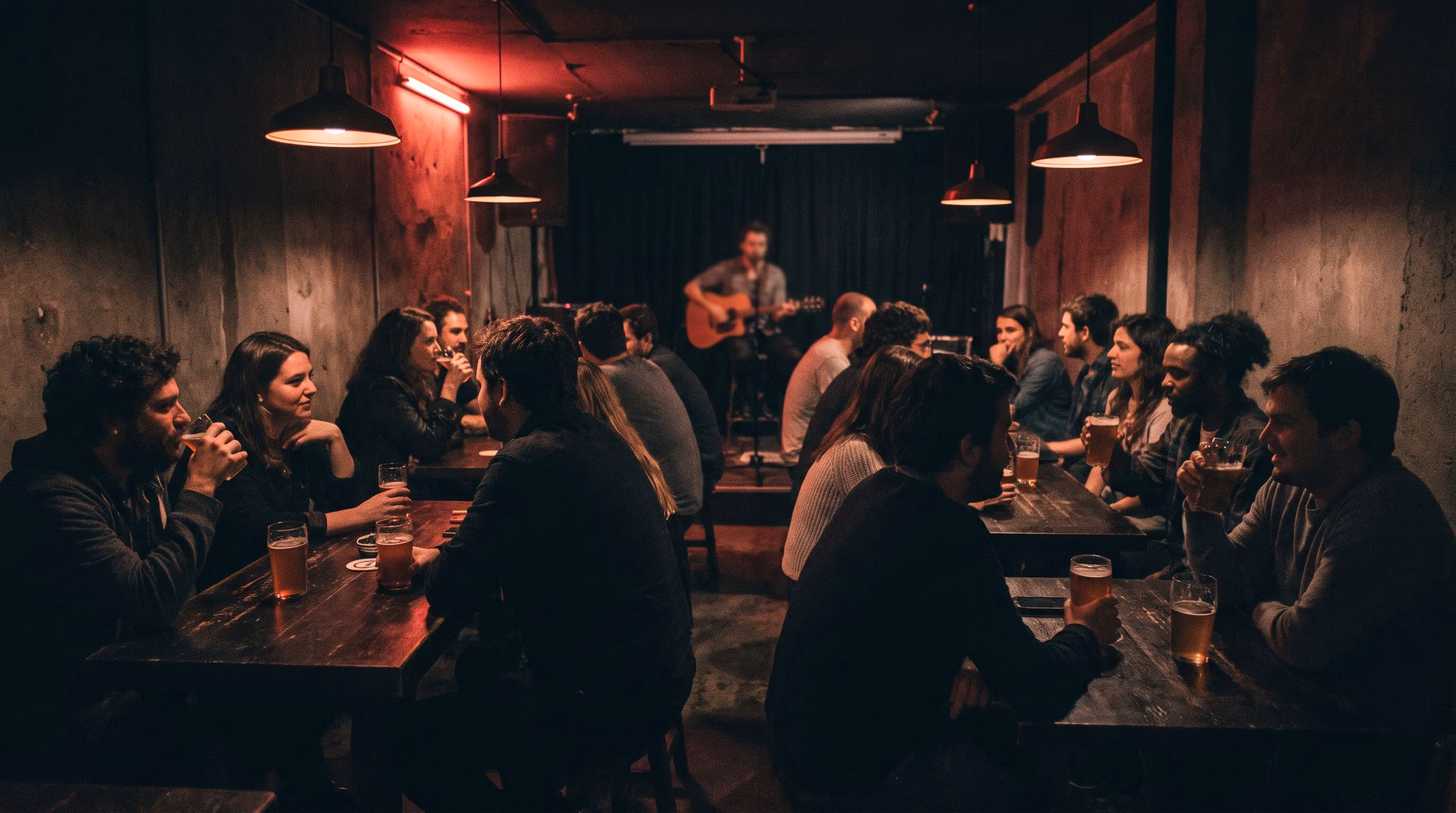 Moody small venue bar scene with people in red light