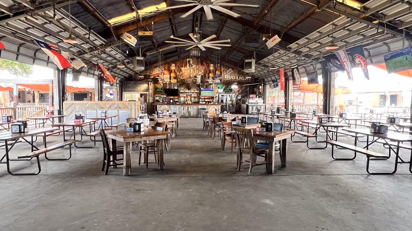 The icehouse room with picnic tables and ceiling fans at Brewster Street Downtown