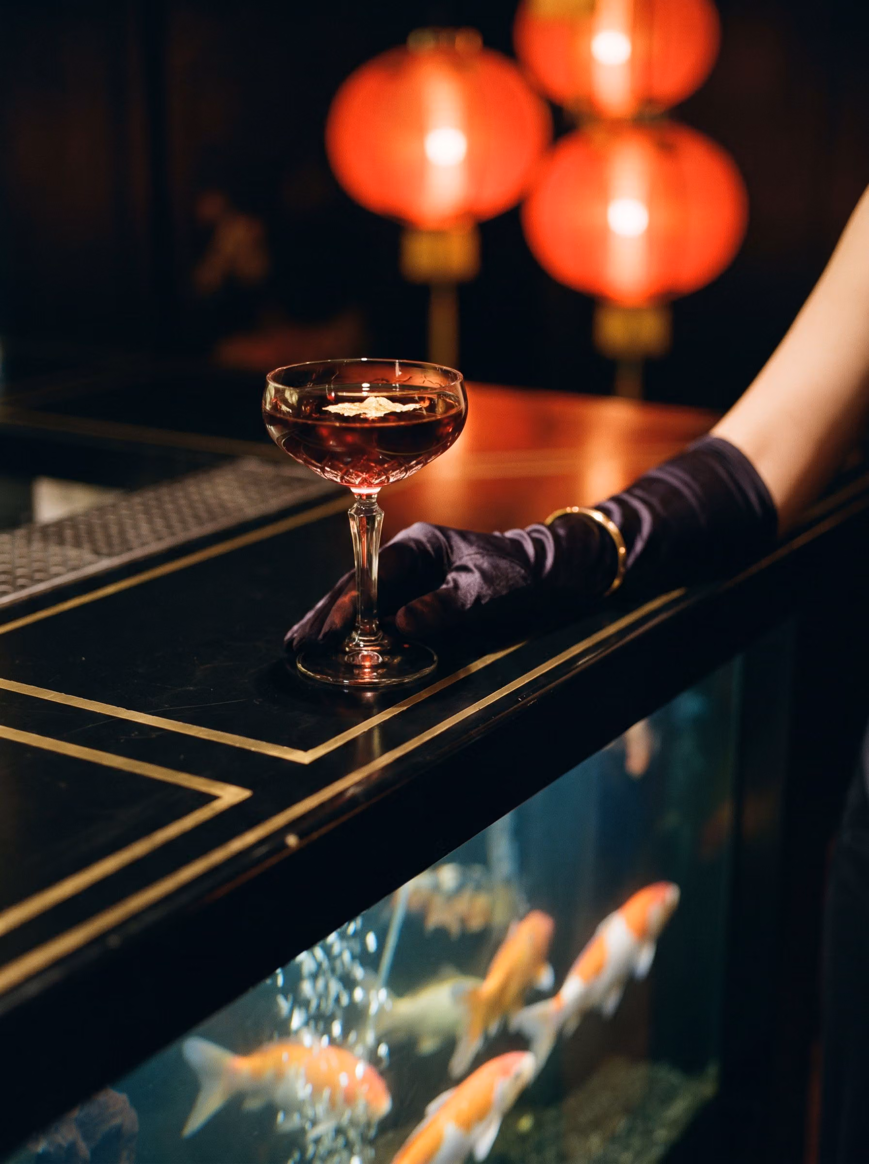 A cocktail resting on the glass of the Koi Bar