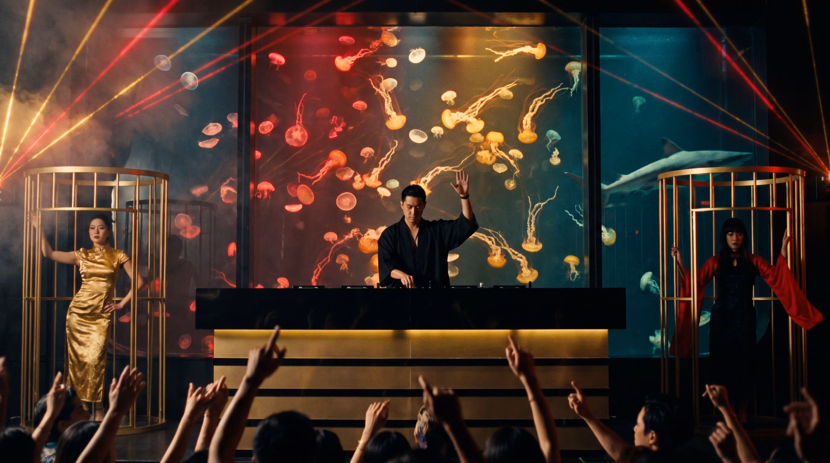 The DJ in front of the Jellyfish Wall, red and gold lasers fanning over the crowd