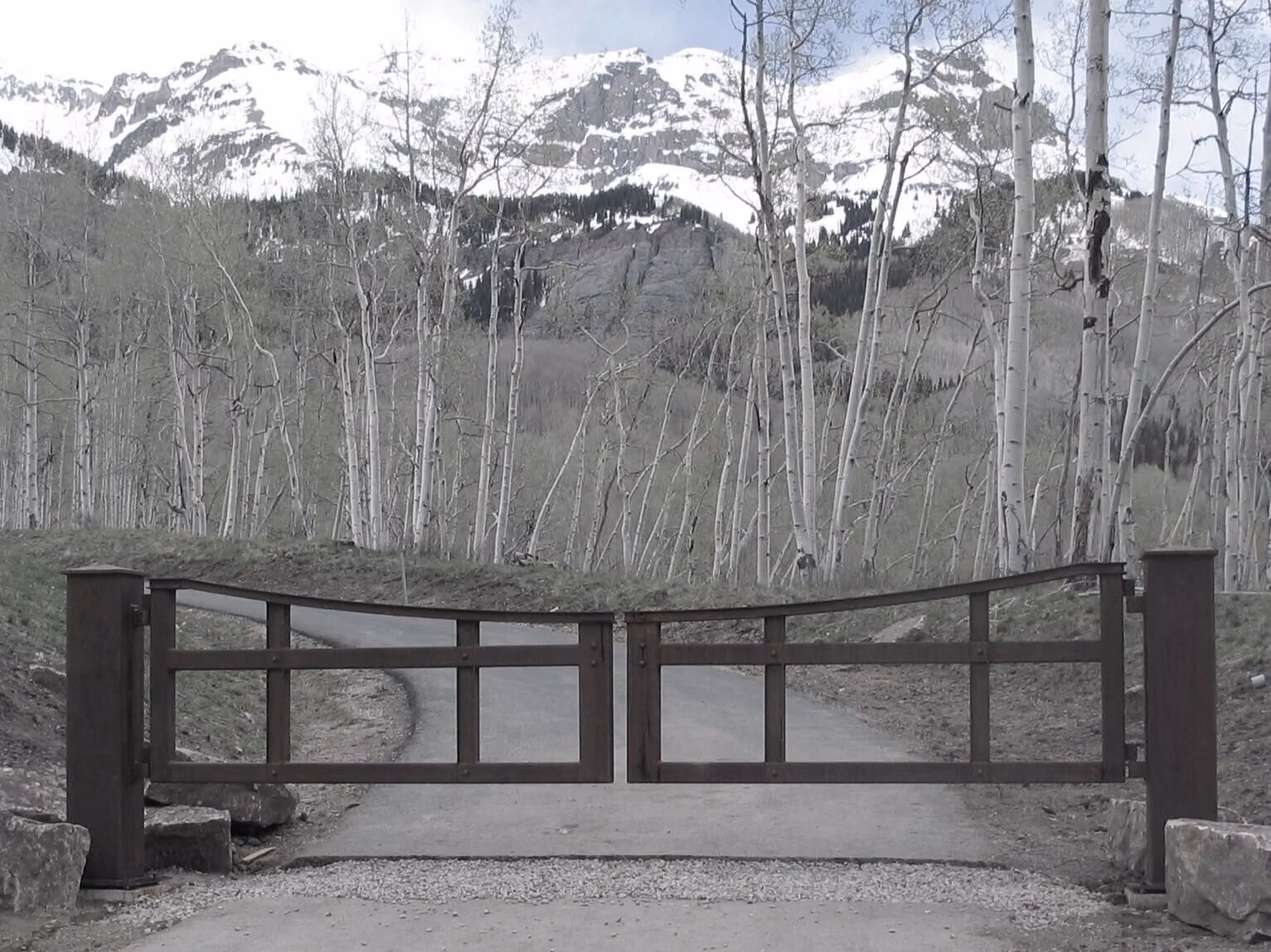 A forged gate and fence across a snowfield