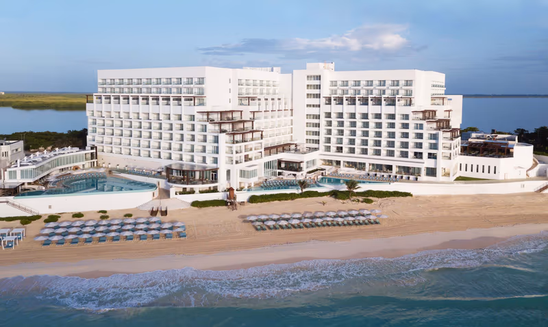 The white beachfront tower of Sun Palace on the Cancun shoreline