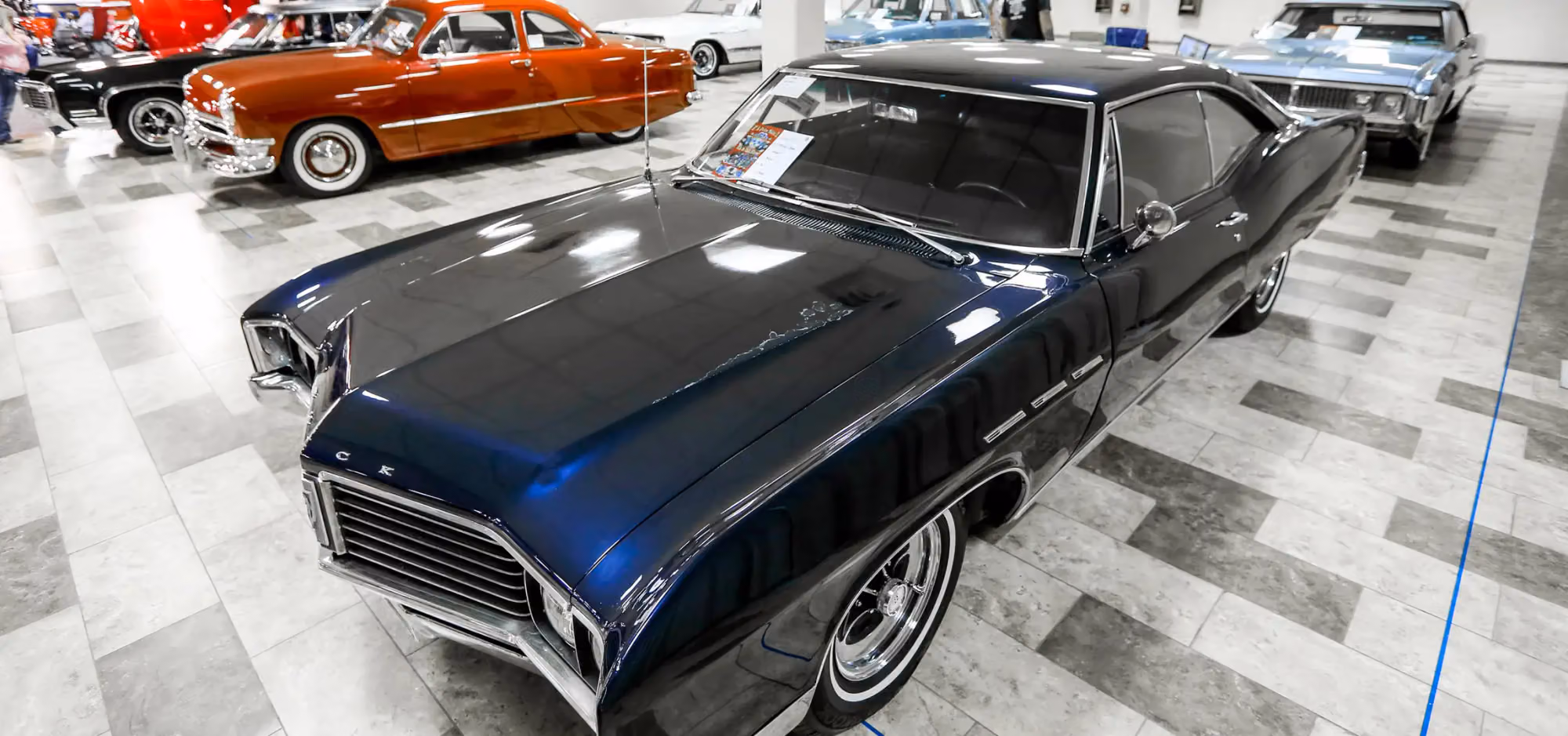 A black sixties Buick in a row of show cars