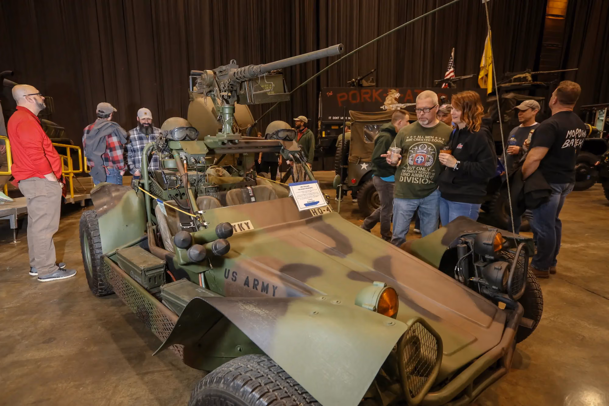 An army jeep with visitors looking it over
