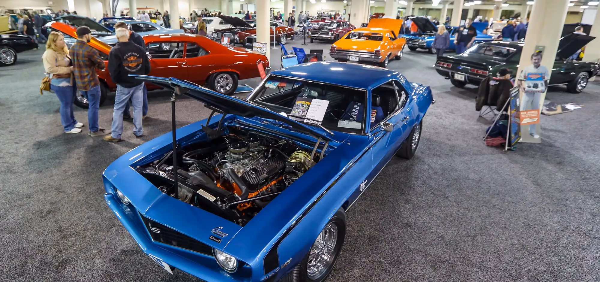 A blue Camaro in the swap meet aisle