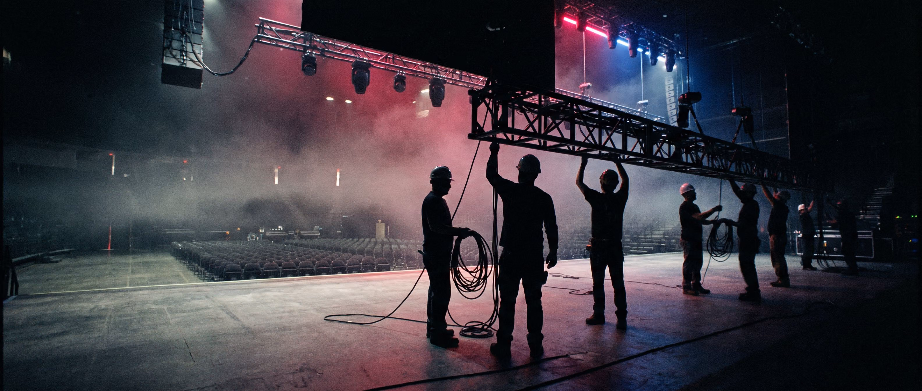 Crew rigging lights on an empty stage before doors open