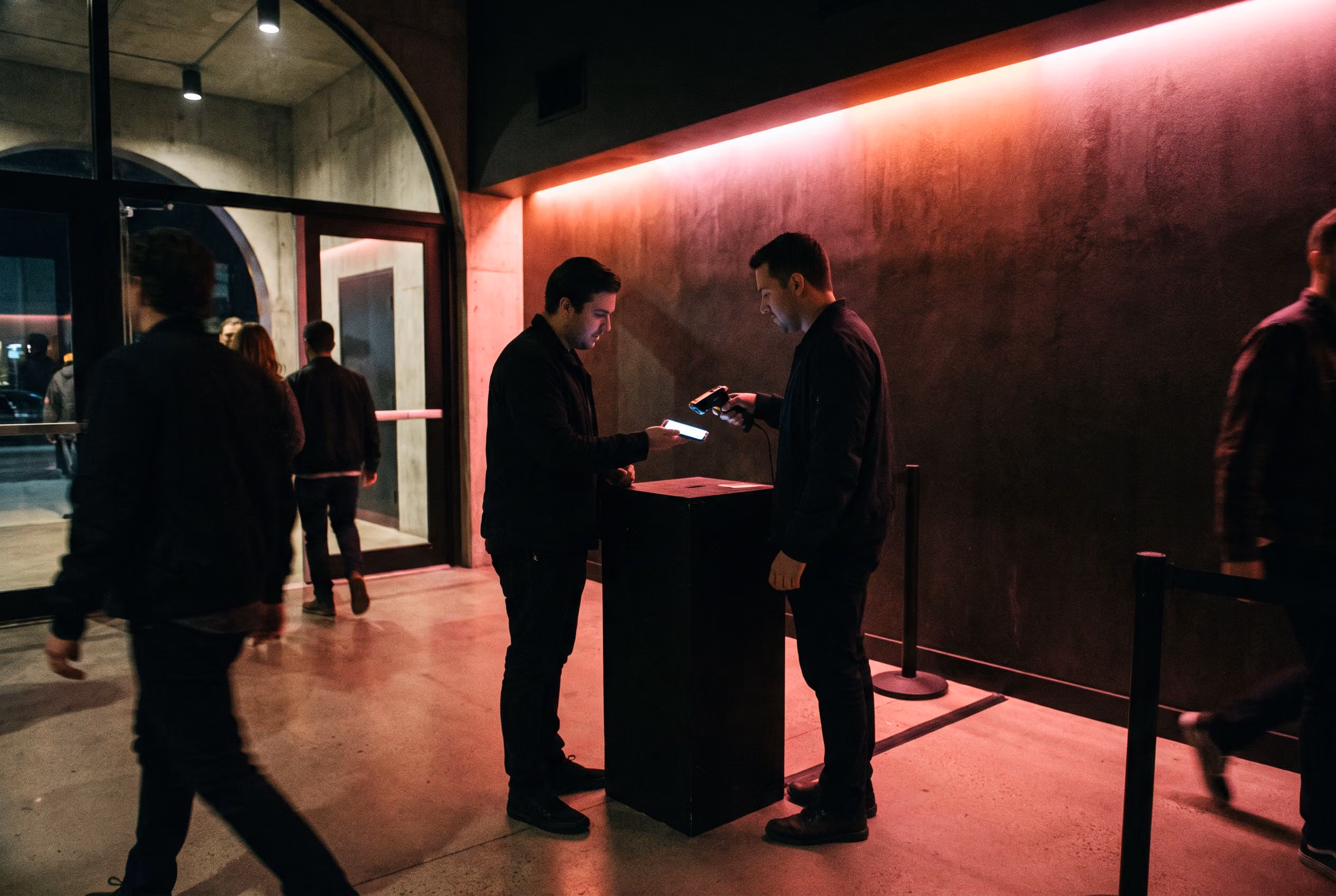 Staff scanning mobile tickets as guests enter a venue at night