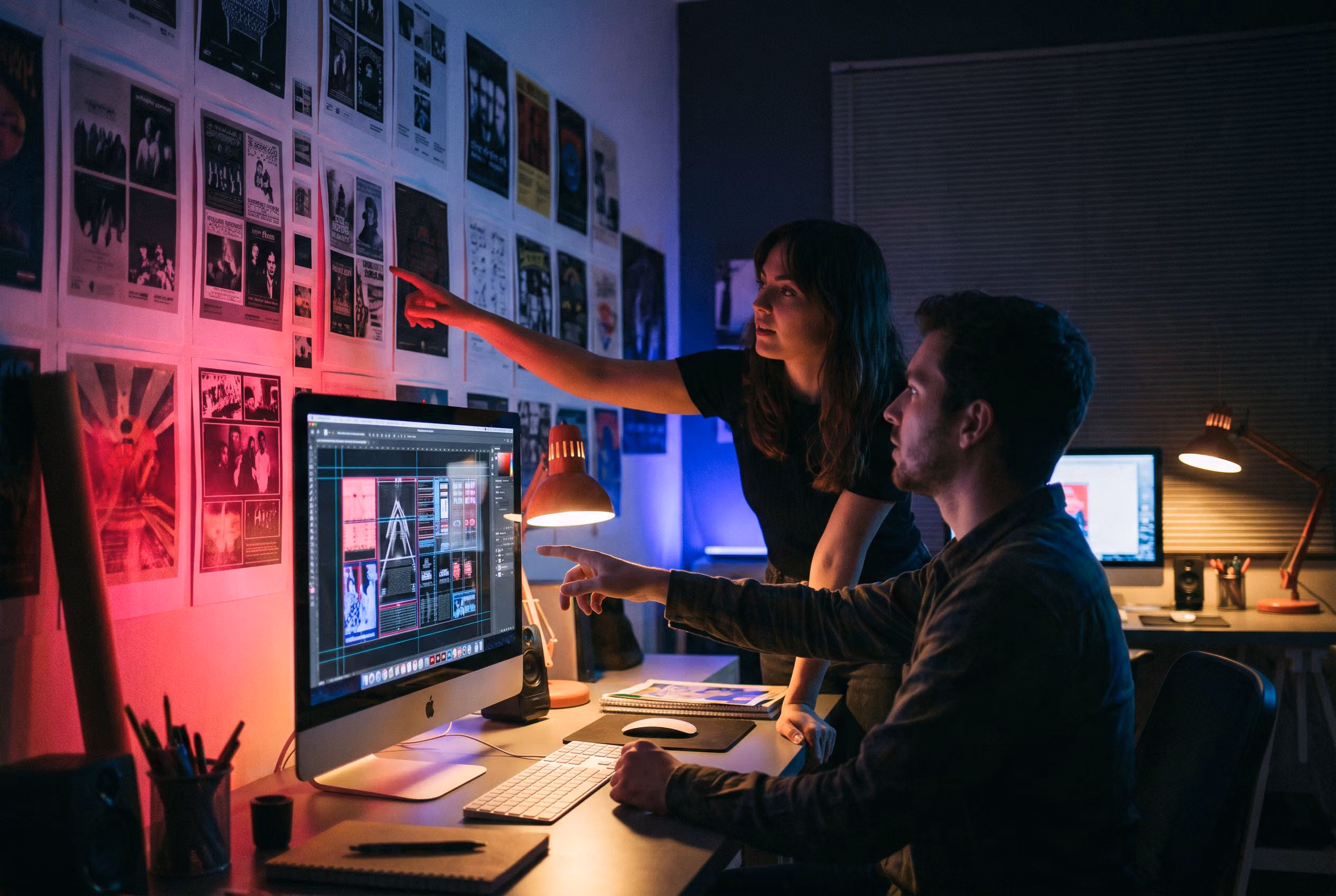 Designers reviewing concert poster layouts in a dark studio