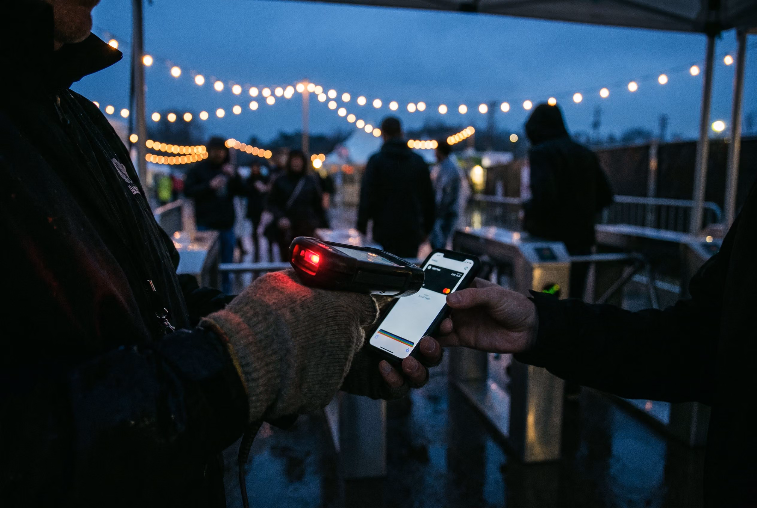 Ticket being scanned at a venue gate at dusk