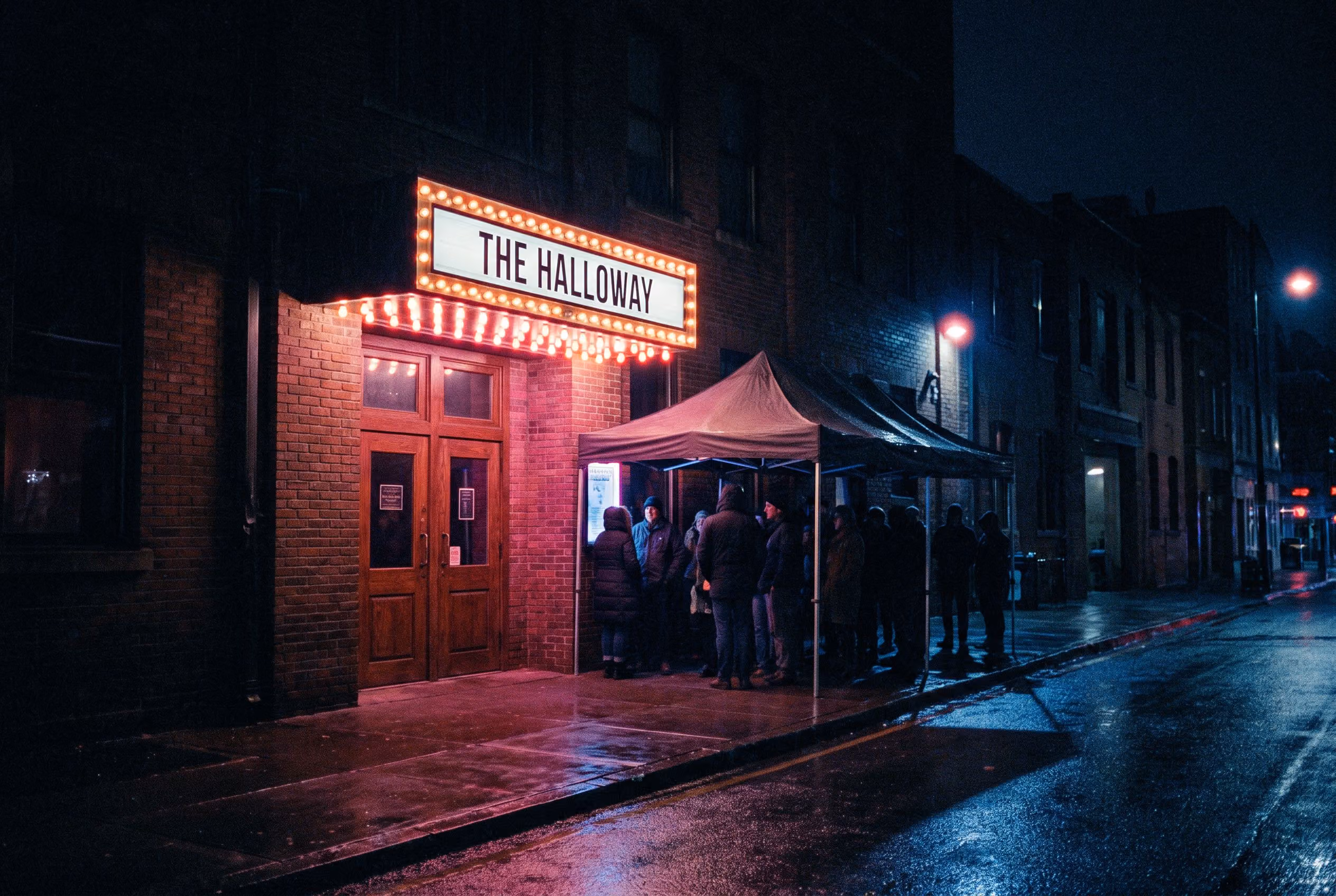 Independent venue marquee lit at night with a queue under the canopy