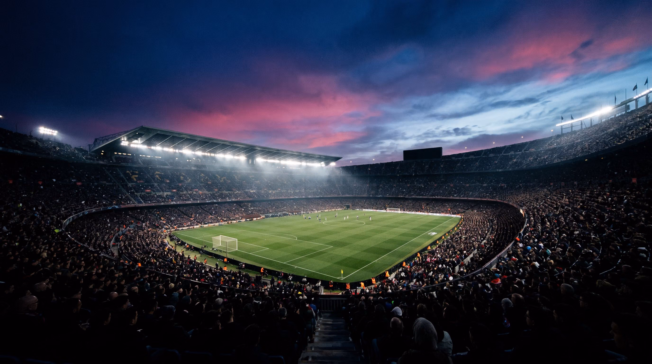 Packed stadium under floodlights at dusk