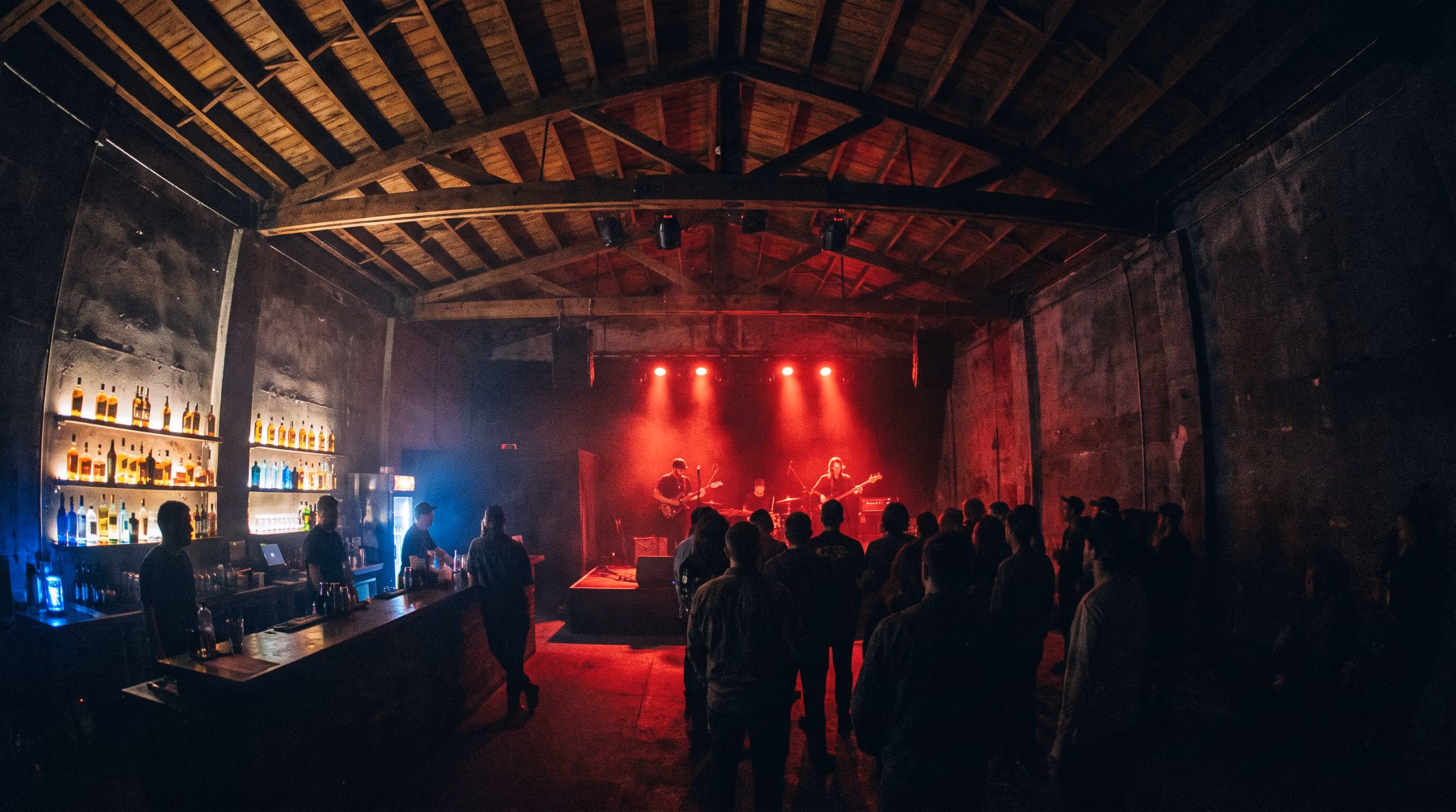 Band performing on the intimate black box stage under red lights