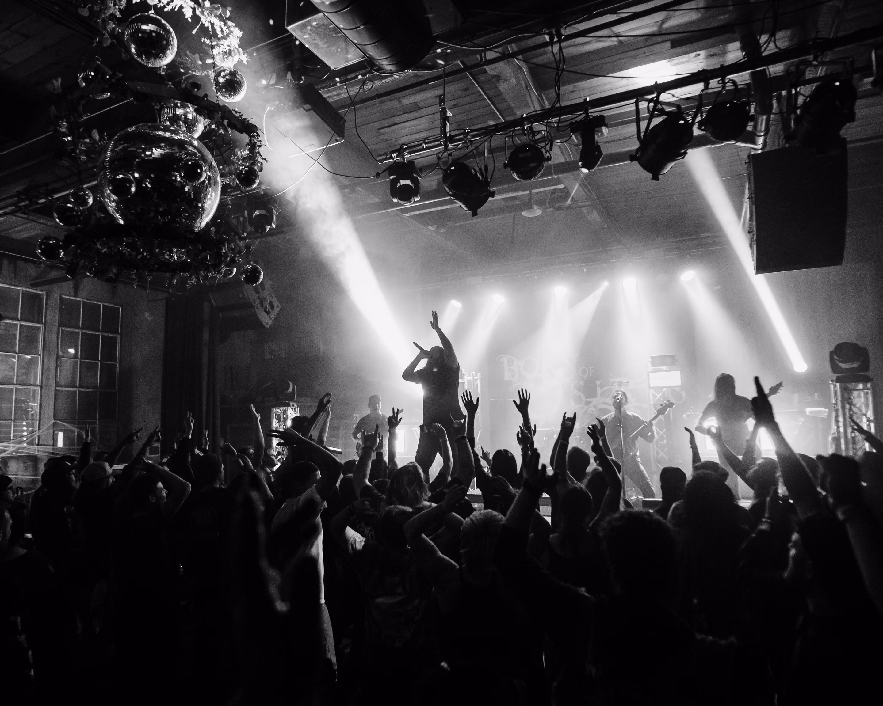 Band performing on the intimate black box stage under red lights