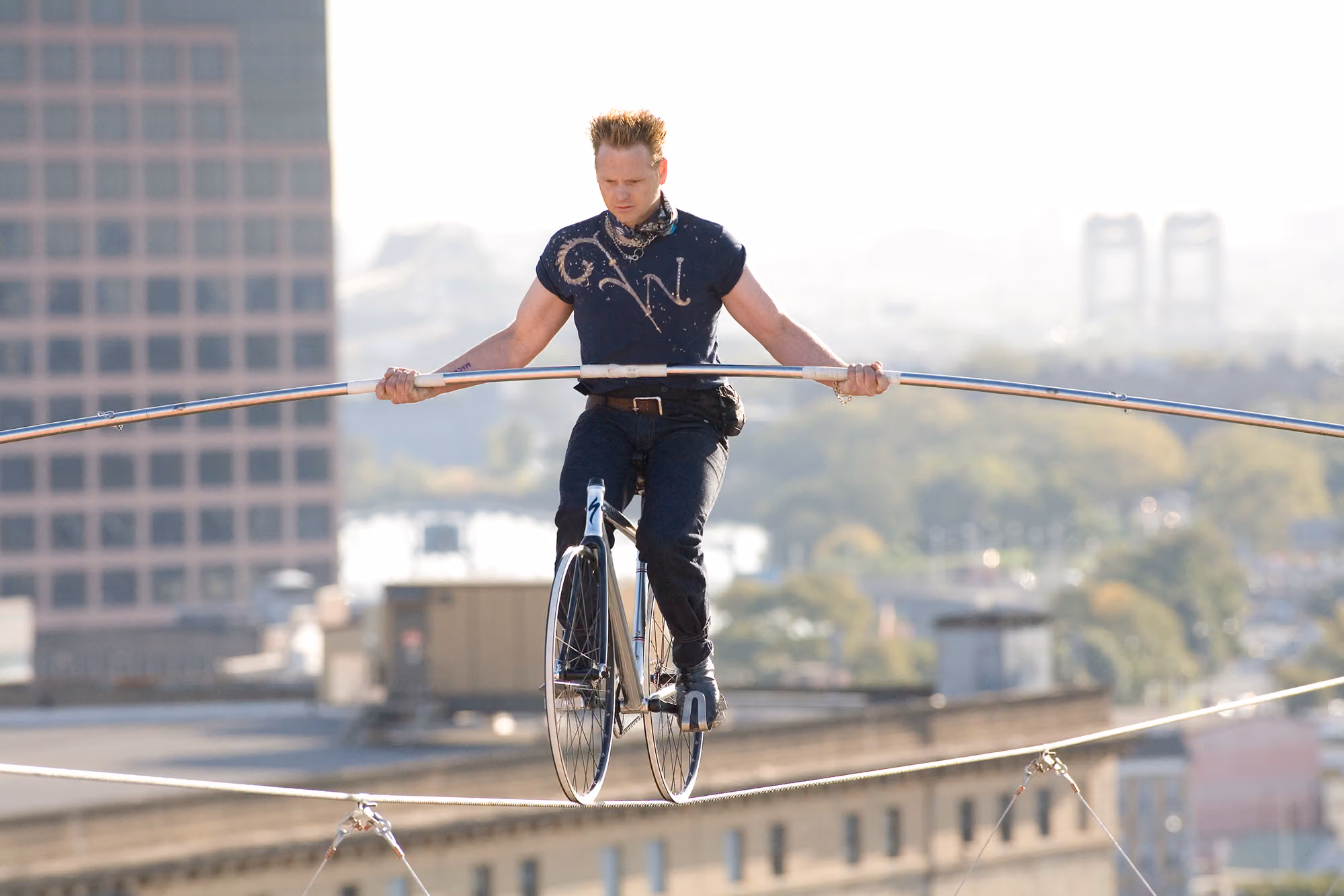 Nik Wallenda riding a bicycle across a high wire outdoors