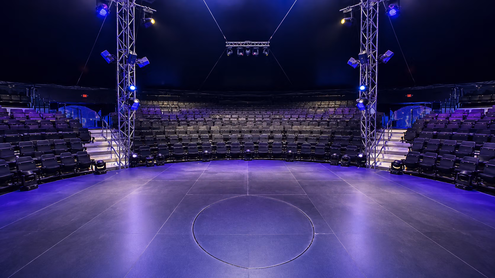 Interior of the round grand big top set for an event with stage lighting
