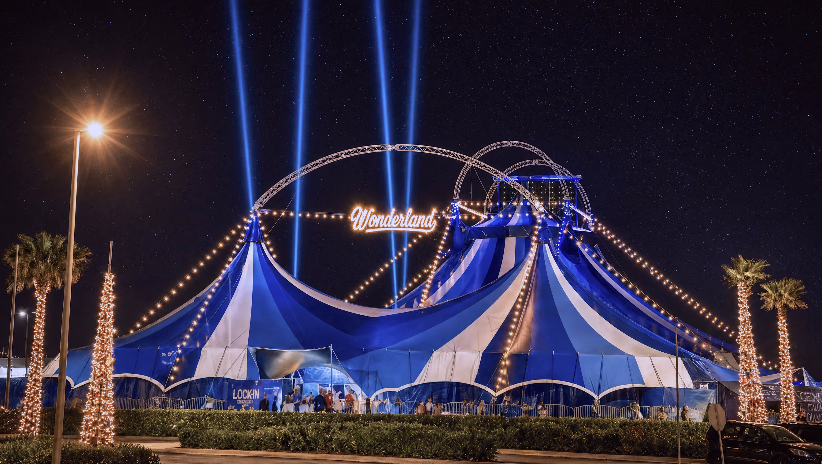 The Wonderland big top structure lit at night