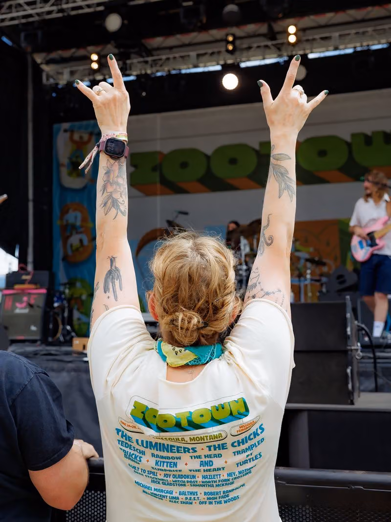 Fan with arms raised in front of the stage