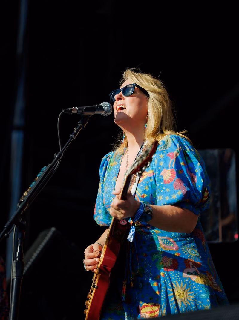 Singer in a floral shirt performing at the microphone