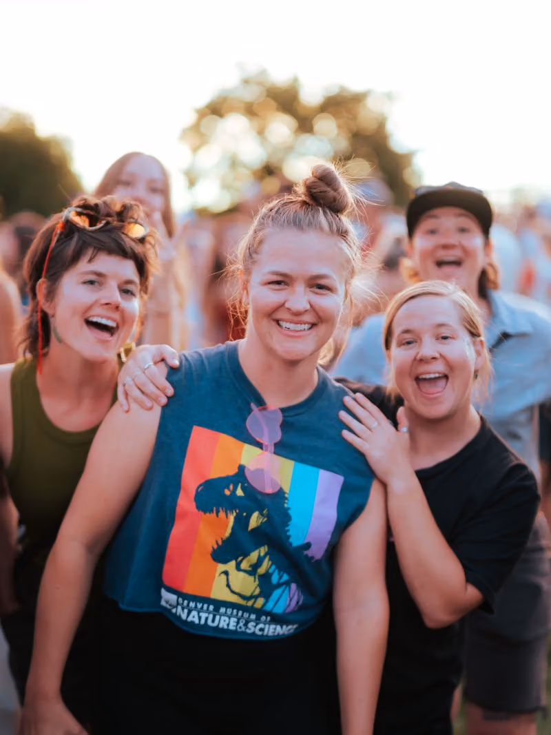 Three friends laughing together in the crowd
